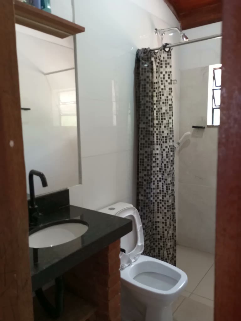 Banheiro com bancada de granito e revestimento em pastilha