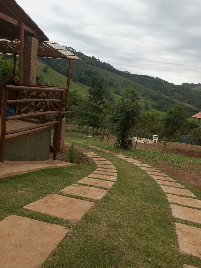 Caminho de pedra no gramado até a varanda do chalé