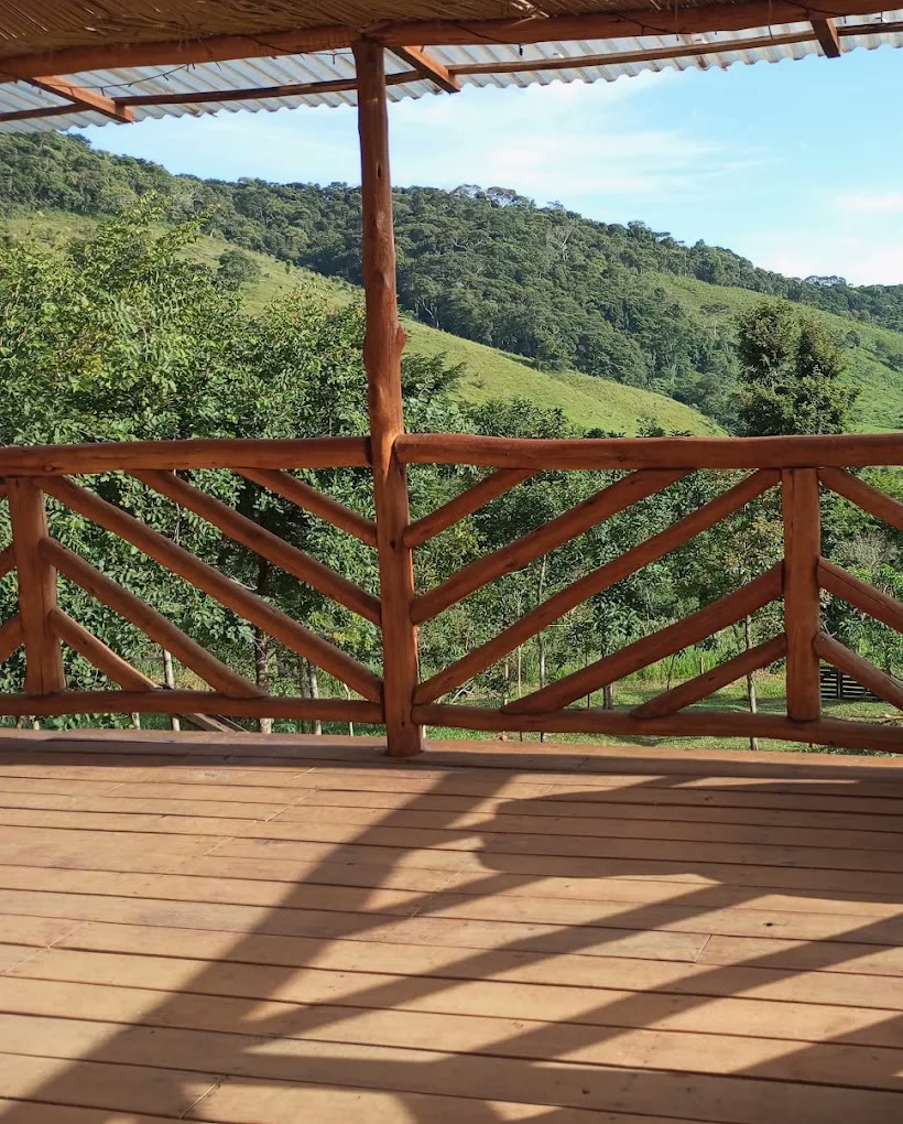 Varanda com guarda-corpo de madeira e vista da serra